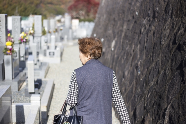 墓地を訪れる高齢の女性