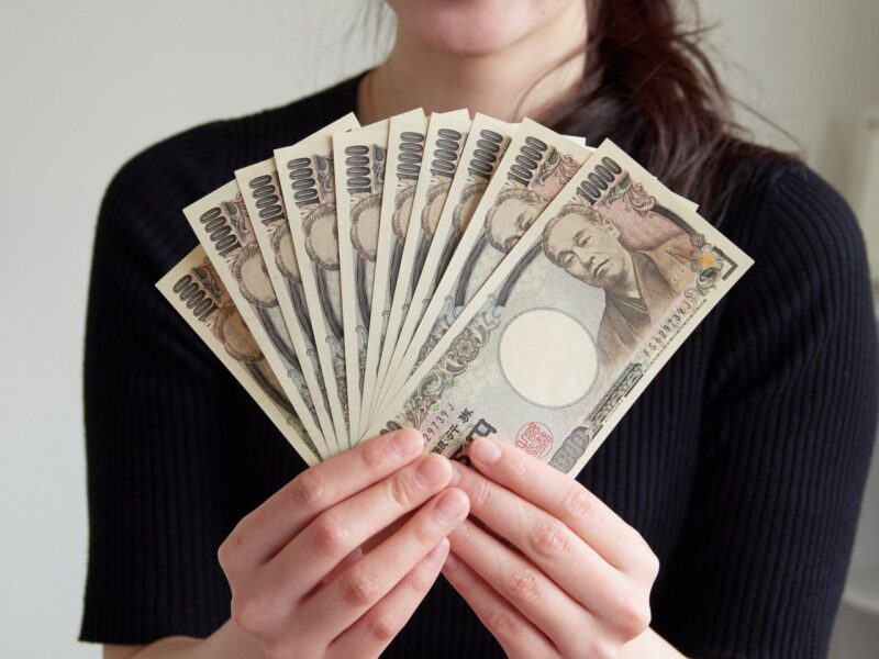 1万円札を広げる女性