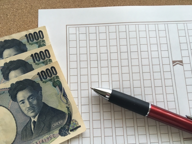 原稿用紙とボールペンと千円札