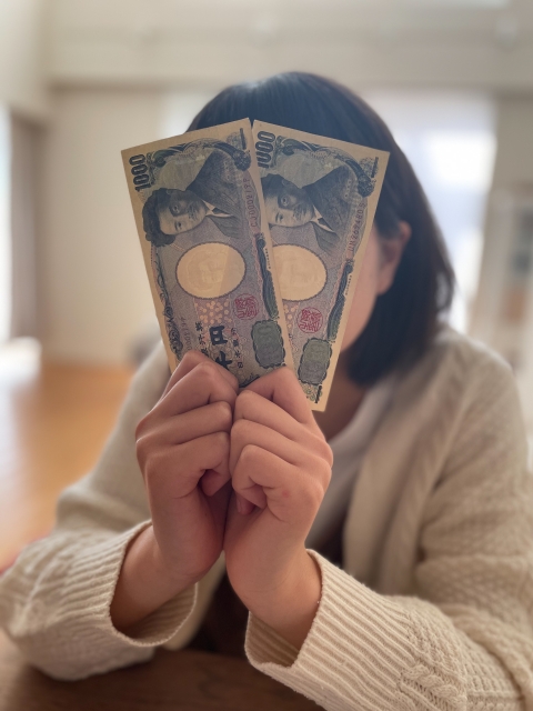 千円札を持つ女性