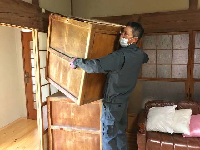 遺品整理で家具を運ぶ男性スタッフ