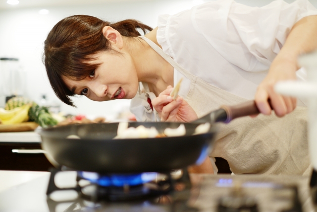 野菜を炒める料理研究家の女性