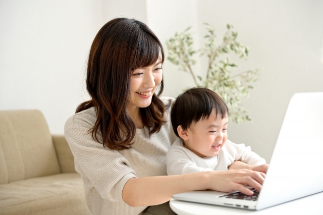 子どもと一緒にパソコンを操作している笑顔の女性