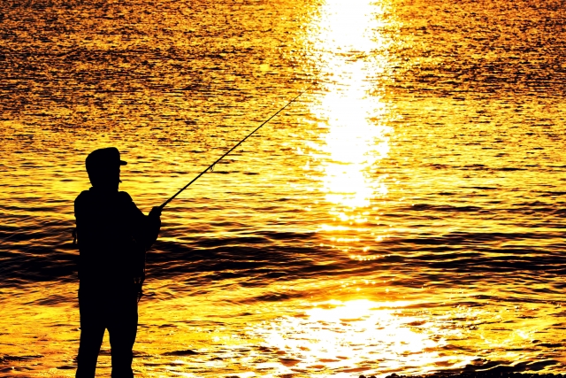 夕日を背景に釣りをする人