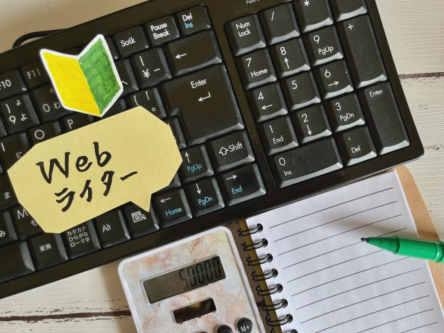 パソコンキーボードに置かれた手書きの初心者マークと「Webライター」の文字