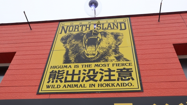 「熊出没注意」の看板がかかっている建物
